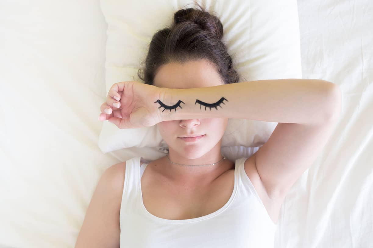 زن با چشمان کشیده شده روی بازو می خوابد